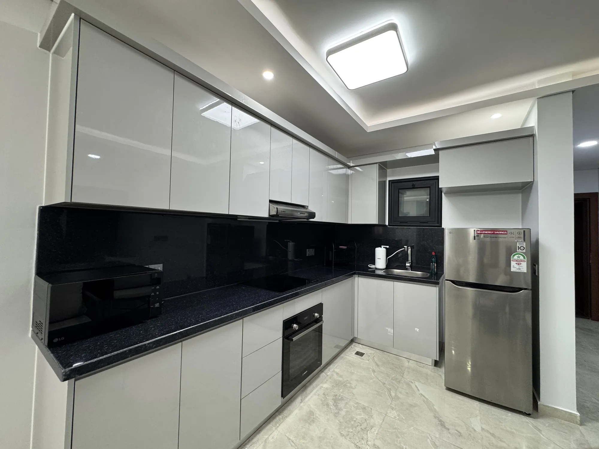 Fitted kitchen with glossy cabinets and black counters